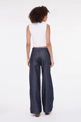Pantalón de denim azul oscuro de tiro alto y corte wide leg, con amplios bolsillos delanteros y costuras pespunteadas en color contrastante.