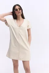 Vestido corto negro con escote en V, mangas cortas abullonadas, silueta suelta y costuras visibles en el frente y la espalda.