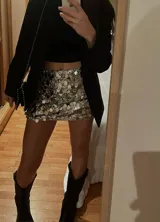 Minifalda plateada con lentejuelas circulares, tiro bajo y cintura elástica.