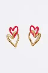 Caravanas con diseño de corazones entrelazados, compuestas por un corazón superior pequeño esmaltado en rojo y un corazón inferior de mayor tamaño con acabado dorado y textura orgánica.