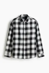 Camisa de franela de algodón suave con estampado a cuadros, cuello inglés, cierre frontal de botones, mangas largas con puños abotonados y bajo redondeado.