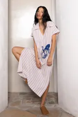 Túnica larga con cuello tipo camisa, de lino a rayas verticales verdes y blancas, con bordado azul en el frente.