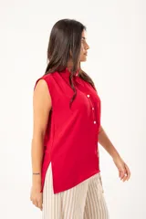 Camisa roja sin mangas con cuello mao adornado con un volado y cierre frontal con botones.