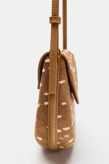 Bolso bandolera de diseño estructurado, con cuerpo en estampado animal tipo cervatillo en tonos marrón y blanco. Cuenta con solapa curva, cierre de botón imantado, bolsillo interior con cremallera y correa larga ajustable.
