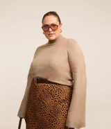 Sweater de punto color beige, con cuello alto y mangas largas acampanadas.