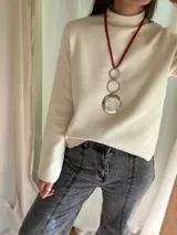 Collar largo con cordón rojo, dije plateado con tres aros de acero quirúrgico de diferentes tamaños y medallón de guampa engarzado en alpaca. Se cierra con cadena de acero quirúrgico con mosquetón para regular.