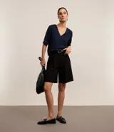 Blusa Cortelle de corte holgado confeccionada en crepé, con escote en V delantero y trasero, y mangas cortas. Presenta una tira decorativa entre los hombros en la espalda.