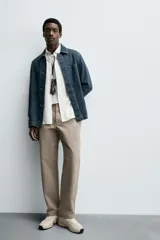 Pantalón de corte recto confeccionado en tejido de algodón con estructura twill, con bolsillos frontales y bolsillos traseros de vivo con botón.
