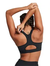 Top deportivo de alto impacto Under Armour, color negro, con tecnología HeatGear® que absorbe el sudor. Presenta diseño de compresión, correas ajustables con cierre de gancho y logo de la marca estampado en el centro.