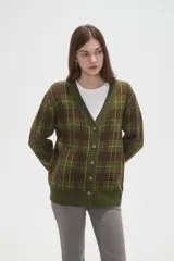 Cardigan de punto con diseño de cuadros, cuello en V y cierre frontal con botones. Presenta un corte holgado y mangas largas.