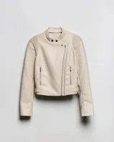 Campera estilo motero de símil cuero en color beige, con cuello alto, cierre frontal asimétrico y paneles acolchados en los hombros.