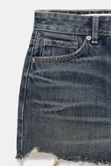 Short de denim tiro medio con trabillas, cinco bolsillos, diseño roto y bajo sin costuras. Cierre frontal con cremallera y botón metálico.