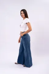 Pantalón de jean corte wide leg con costura central vertical, tiro medio y cierre frontal con botones.