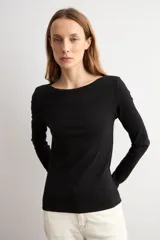 Remera de manga larga en color blanco, con escote bote y corte ajustado al cuerpo.