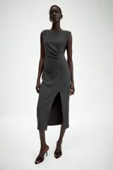 Vestido midi sin mangas de cuello redondo, con detalle de drapeado en el delantero y abertura frontal en el bajo. Cierre posterior con cremallera oculta.