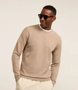 Suéter de punto color borgoña, con cuello redondo, sisas ligeramente desplazadas y bajo y puños acanalados.