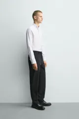 Camisa slim fit de algodón en color blanco, con cuello smoking y manga larga con puño doble abotonado.