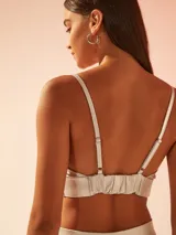 Top corto tipo bralette de tela satinada brillante, con escote en V y breteles finos ajustables.
