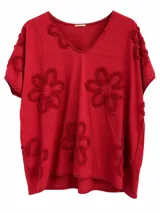 Remera roja de manga corta, cuello en V y diseño holgado, decorada con flores en relieve.