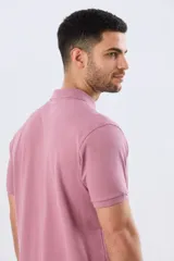 Remera polo de piqué de algodón color azul, de manga corta, con cuello camisero, cierre frontal de dos botones y pequeño logo bordado en el pecho.