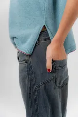 Jean de tiro medio con diseño de pierna amplia y corte holgado, confeccionado en denim azul. Cuenta con bolsillos delanteros y traseros funcionales.