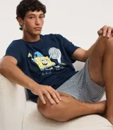 Pijama corto masculino de algodón, compuesto por una remera azul marino con estampado de Bob Esponja y un short a rayas blancas y grises con cintura elástica.
