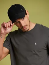 Gorro con visera color negro, confeccionado en algodón con logo metálico dorado.
