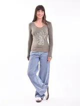 Remera de manga larga color rojo, con estampa frontal abstracta en color blanco que representa un rostro.