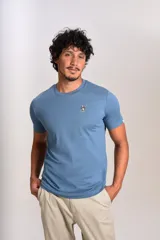 Remera de cuello redondo y manga corta en color azul, con un pequeño bordado de un pingüino esquiador en el pecho.