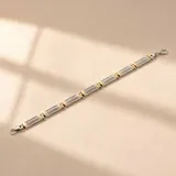 Pulsera combinada de plata y oro, con diseño articulado de eslabones rectangulares y estriados con cierre de mosquetón.