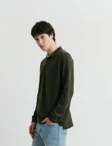 Remera de manga larga con cuello polo, confeccionada en tejido de punto canalé francés. Presenta abotonadura frontal con botones de madera y detalles a contratono en la cartera y el interior del cuello.