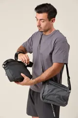 Bandolera negra de tela impermeable con correa regulable.