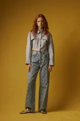 Camisa corta a rayas verticales grises y blancas, con cuello clásico, cierre frontal con botones y mangas largas con puños abotonados.