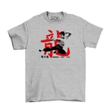 Remera gris de algodón con estampa frontal de Bruce Lee en acción sobre un ideograma chino rojo y fechas conmemorativas.