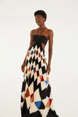 Vestido largo plisado con estampado geométrico de rombos en tonos negro, blanco, azul, rojo y naranja. Cuenta con escote halter con finos tirantes, diseño strapless con fruncido en el centro del busto y aberturas laterales en la cintura.