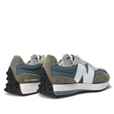 Championes urbanos New Balance, con capellada de gamuza color gris, detalles en celeste y beige, logo "N" blanco en los laterales, entresuela blanca y suela de goma negra.