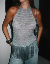 Top tejido plateado con escote halter y flecos largos en el dobladillo.