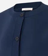 Cardigan de punto color azul marino, con corte holgado, cuello redondo, cierre frontal con botones y mangas largas con puños ajustados.