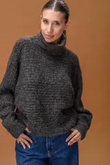Sweater de cuello alto confeccionado en tejido de punto con sutiles destellos de lurex. Presenta mangas largas con puños ajustados y un calce holgado y cómodo.