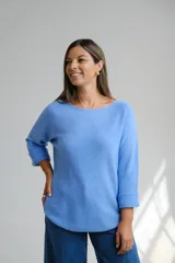 Sweter de punto color celeste, con escote a la base y mangas tres cuartos con puños doblados. De corte holgado y diseño básico.