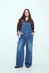 Camisa tipo leñadora de corte oversize, con estampado de cuadros en tonos negro y marrón. Presenta cuello clásico, cierre frontal con botones y mangas largas con puños abotonados.