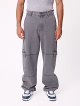 Jean de corte wide leg en color gris con efecto desgastado. Presenta diseño tipo cargo con bolsillos laterales con solapa y costuras reforzadas en las piernas.