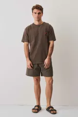 Remera marrón chocolate de calce relajado, con cuello redondo y pequeño bordado al tono en el pecho.