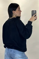 Buzo de cuello redondo, corte oversize, con mangas largas y puños elásticos.