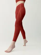 Calza deportiva roja con detalles de costuras y líneas laterales en tono contrastante.