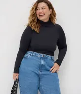 Pantalón mom jeans de tiro alto y corte holgado en caderas y piernas, con bolsillos, presillas para cinturón y cierre frontal con botón.