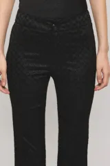 Pantalón sastrero negro con lúrex, de calce slim, botamanga flare y bolsillos ojal en la espalda. Presenta cierre frontal con broche personalizado y botón auxiliar interno.