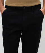 Pantalón de corte recto con textura de líneas verticales, confeccionado en algodón. Presenta cintura estructurada con presillas, cierre tradicional con botón y bolsillos funcionales.
