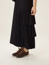 Vestido midi de morley color negro, con escote en V, mangas cortas y diseño con volados asimétricos en el lateral inferior.
