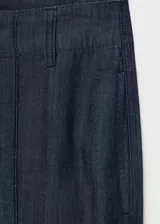 Pantalón de tiro alto con diseño wide leg, confeccionado en tejido de algodón y lyocell estilo denim. Presenta costuras verticales decorativas, bolsillos laterales y cierre oculto con botón, gancho y cremallera.